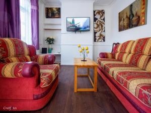 a living room with two red couches and a table at 12 Cornwallis Lodge Family Room 1 in Stoke on Trent