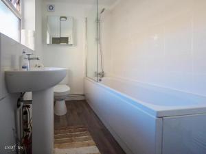 a bathroom with a sink and a toilet and a tub at 12 Cornwallis Lodge Family Room 1 in Stoke on Trent