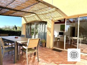 a patio with a wooden table and chairs at Domaine Saint Antoine in Rieux-Minervois