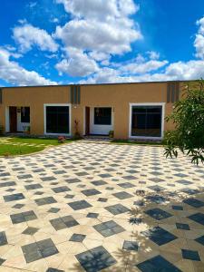 a building with a checkered floor in front of it at Nico Garden Apartment in Dodoma +43 photos