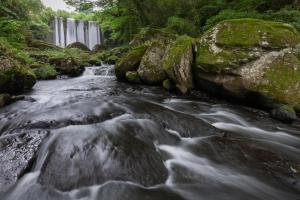 a river with a waterfall in the background at Sanso Tensui in Hita