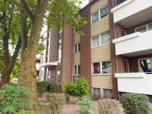 an apartment building with a tree in front of it at ImmoStay Waterfront Apartments - Balkon über Bremen & Parking in Bremen