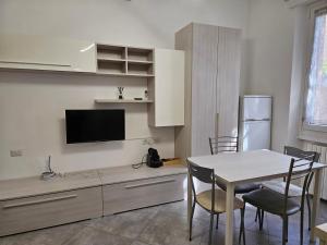 a kitchen with a dining room table and a tv at Il Sesto tasso in Sesto San Giovanni