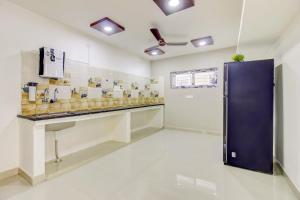 a kitchen with a large blue door in a room at Hotel O R D CONVENTION & LUXURY ROOMS in Hyderabad