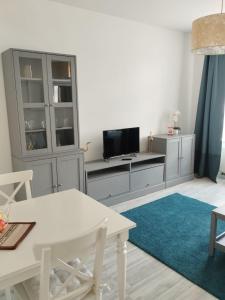 sala de estar con mesa blanca y TV en Mikra Homes24 in Chemnitz, en Chemnitz