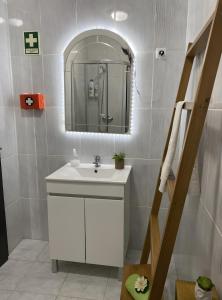 a bathroom with a white sink and a mirror at Alojamento D Duarte in Gouveia
