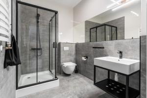 a bathroom with a sink and a shower and a toilet at IND.U Apartamenty in Kołobrzeg +80 photos