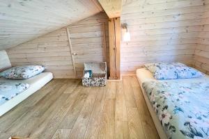 Un dormitorio con dos camas en una cabaña de madera. en Chatka in Roztiezi, en Roztěž