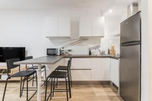 a kitchen with a table and chairs and a refrigerator at Home2Book Chic Apartment Near The Sea, La Garita in La Garita