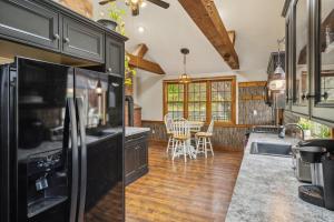 a kitchen with black appliances and a dining room at Coastal Comfort with Stunning Harbor Views home in Plymouth
