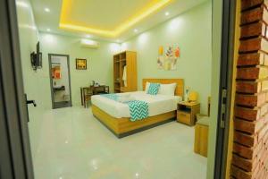 a bedroom with a bed and a desk in it at Hy Viên boutique Garden & Swimming pool in Cồn Giả Viên