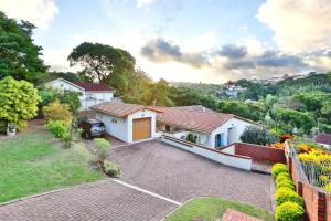 a house with a driveway and a yard at Lily's Cottage in Durban