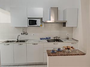 a kitchen with white cabinets and a counter top at Casa Gelsomino by Holiday World in Donnalucata