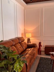 a living room with a brown leather couch at Stay Central Loft Panampilly in Cochin