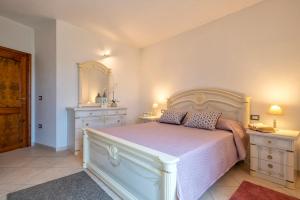 a bedroom with a large bed with two night stands at Villa Cristina in Tergu