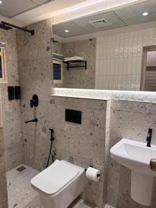 a bathroom with a white toilet and a sink at Stay Central Loft Panampilly in Cochin