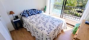 a bedroom with a bed with a white and blue comforter at House 3 rooms with garden near the sea in Bandol