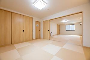 an empty room with wooden cabinets and a tiled floor at Irodori Hotel TEN in Fukuoka