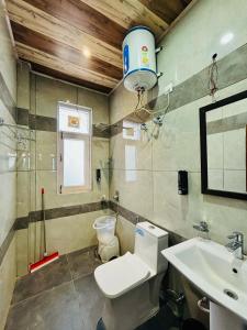 ein Badezimmer mit Toilette und Waschbecken in der Unterkunft Parimahal Cottage in Shimla