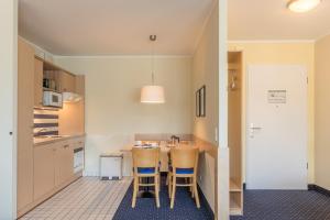 a kitchen with a table and some chairs in it at An de See - im Ostseeheilbad Zingst mit Balkon in Zingst +15 photos