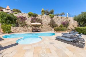 a swimming pool with two lounge chairs and an umbrella at Villa Cereseto in Abbiadori
