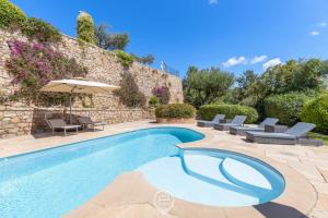 a swimming pool with chairs and an umbrella at Villa Cereseto in Abbiadori