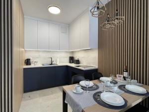 eine Küche mit einem Tisch mit Tellern und Gläsern darauf in der Unterkunft Zakręcona Fala Let's Sea Gąski in Gąski