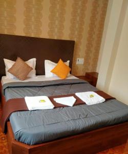 ein Bett mit Handtüchern und Kissen darauf in der Unterkunft J J Lodging in Kolhapur + 7 Fotos