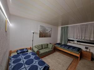a bedroom with a bed and a couch and a window at Messe Apartments Hannover in Hannover