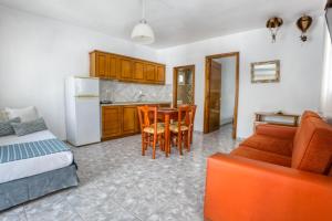 a living room with a kitchen and a table and chairs at Maison Ciel in Agia Paraskevi