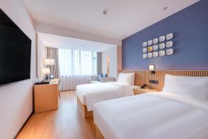 A bed or beds in a room at 深圳宝安国际会展中心桔子水晶酒店