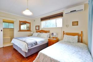 a bedroom with two beds and a mirror at Lily's Cottage in Durban +16 photos