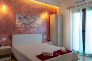 a bedroom with a white bed with red towels on it at Elisabeth in Vourvourou