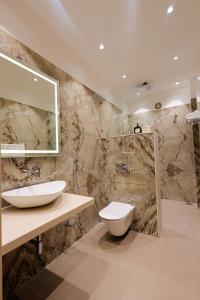 a bathroom with a sink and a toilet and a mirror at The Meera Hotel in Ujjain