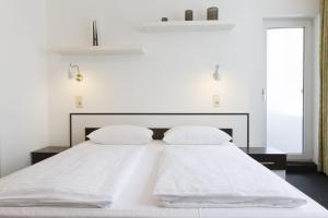 - un lit blanc avec 2 oreillers blancs dans l'établissement Aparthotel VEGA, à Berlin
