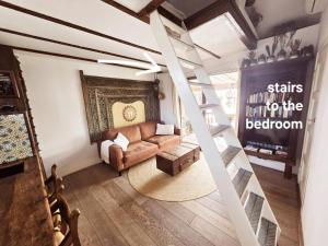 a living room with a couch and a ladder at House boat studio with waterfront terrace in Amsterdam