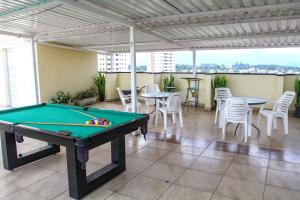 a pool table in a room with tables and chairs at Hotel Flamboyant Taubate in Taubaté