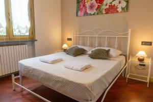 una camera da letto con un letto bianco con due asciugamani sopra di Villa Sun Kiss a Volta Mantovana