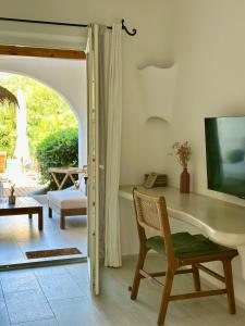 a room with a desk and a chair and a window at Hôtel Palombaggia in Porto-Vecchio