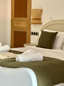 a bedroom with two beds with towels on them at Hôtel Palombaggia in Porto-Vecchio