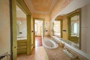 un bagno con un lavandino e un grande specchio di Villa Sun Kiss a Volta Mantovana