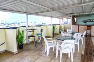 a bar with white chairs and tables on a balcony at Hotel Flamboyant Taubate in Taubaté