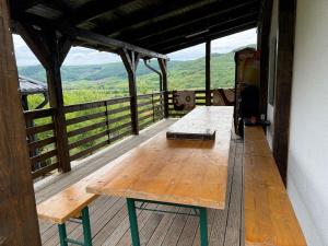 a wooden table on a deck with a view at Cabana cu Livada in Mintiu Gherlii