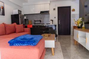 Una sala de estar con un sofá rojo y una cocina. en Kizuri Stays by Neema, en Nairobi