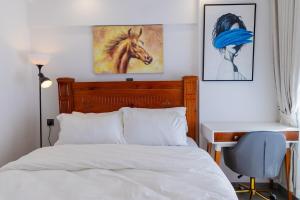 Un dormitorio con una cama y un escritorio y un cuadro de un caballo. en Kizuri Stays by Neema, en Nairobi