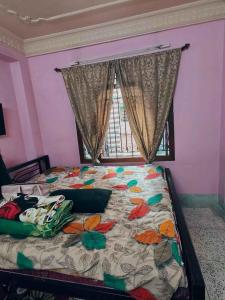 Un dormitorio con una cama con colcha floral y una ventana. en Perfect long stay, en kolkata