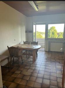 a dining room with a table and chairs and windows at Wohnung für Monteure in Ahlen +3 photos