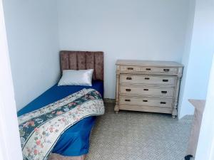 a small bedroom with a bed and a dresser at Maison Fleur in La Goulette