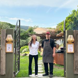 a man and a woman standing in front of a gate at Hôtel Palombaggia in Porto-Vecchio