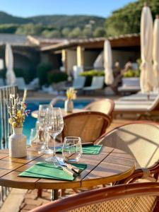 a wooden table with wine glasses on top of it at Hôtel Palombaggia in Porto-Vecchio